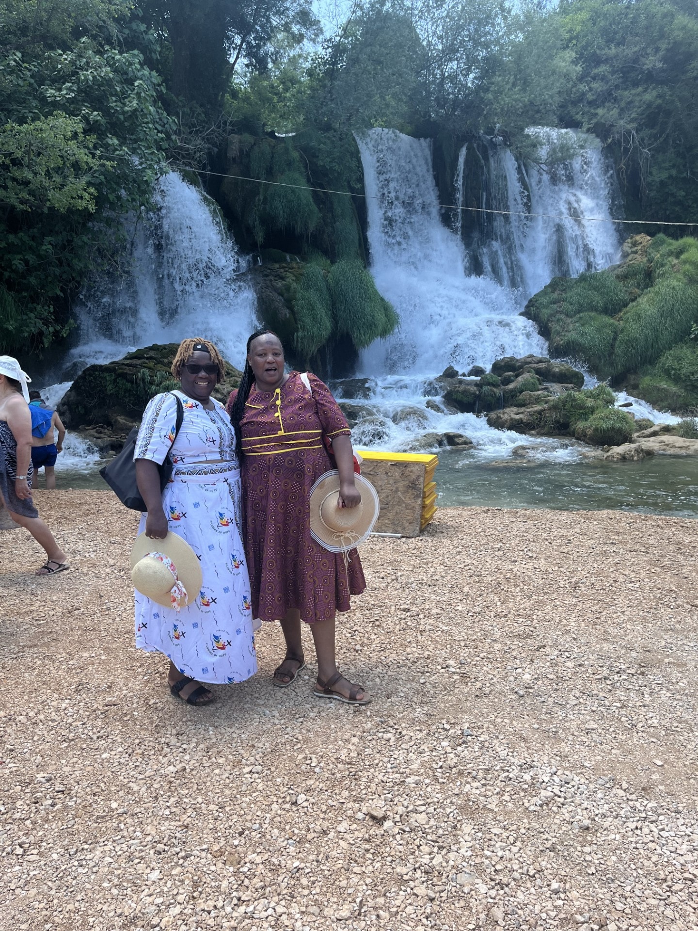 Two travellers posing in front of a stunning waterfall on a weekend getaway