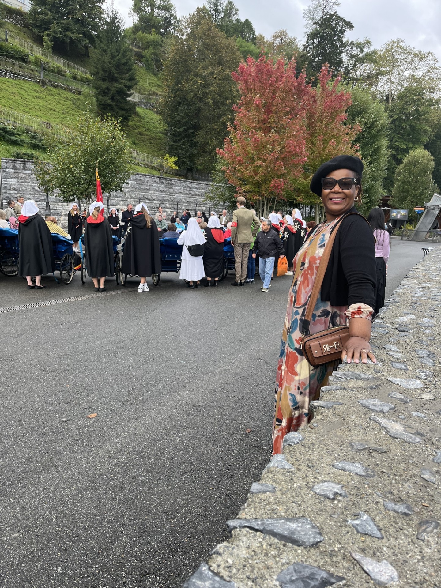 Georgina at the Lourdes sanctuary with pilgrims and the Order of Malta in the background